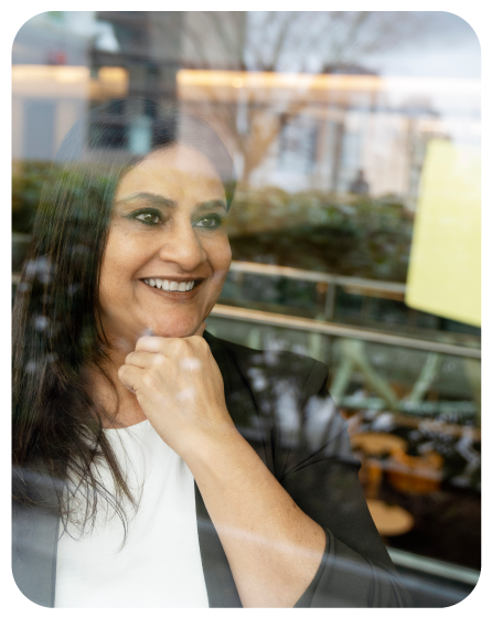 mujer-mayor-sonriente-mirando-a-traves-de-una-ventana