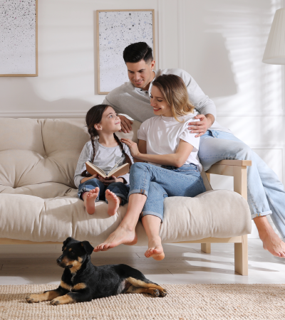 padre-madre-y-nina-sentada-en-su-sala-con-su-perro