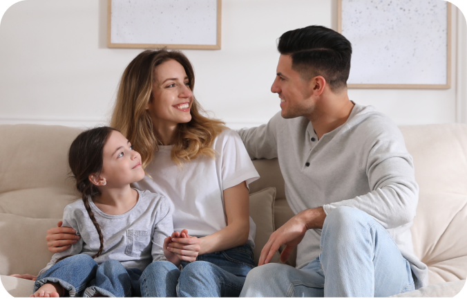 familia-joven-conversando-alegremente-en-el sofa-de-su casa